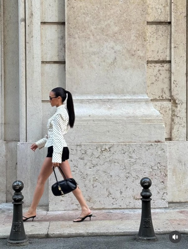 Chemise blanche à pois avec un short noir et un sac à main